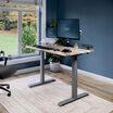 Electric Standing Desk with ComfortEdge in 48x30 Reclaimed Wood in raised position at home